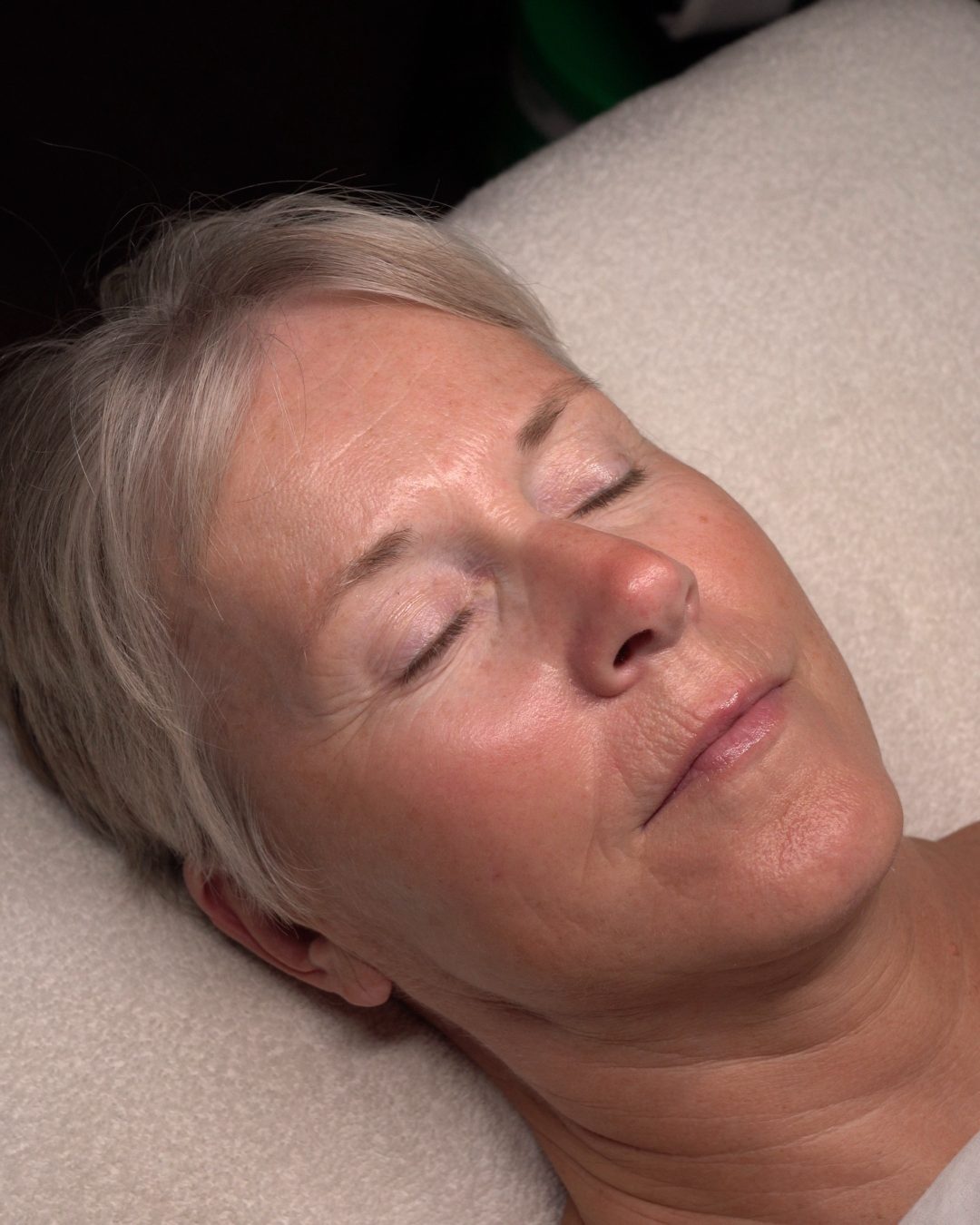 Client relaxing with eyes closed during a Signature facial
